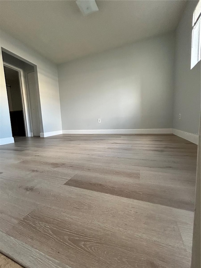 empty room with light wood-type flooring and baseboards