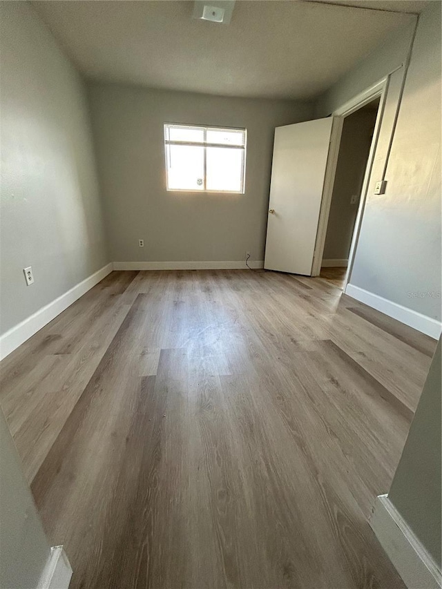 interior space featuring light wood-style flooring and baseboards