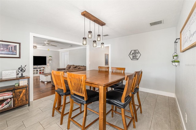 dining room with light wood-type flooring, baseboards, visible vents, and a ceiling fan