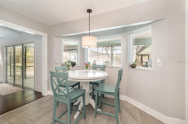 dining room featuring baseboards, a wealth of natural light, and light wood-style floors