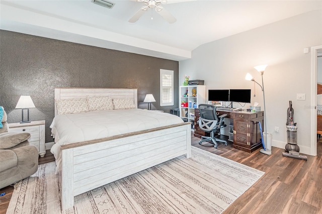 bedroom featuring a ceiling fan, visible vents, baseboards, and wood finished floors