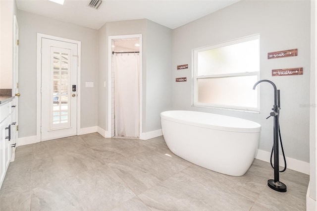 full bath with visible vents, vanity, a shower with curtain, a freestanding tub, and baseboards