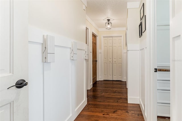 hall with dark wood finished floors and a textured ceiling