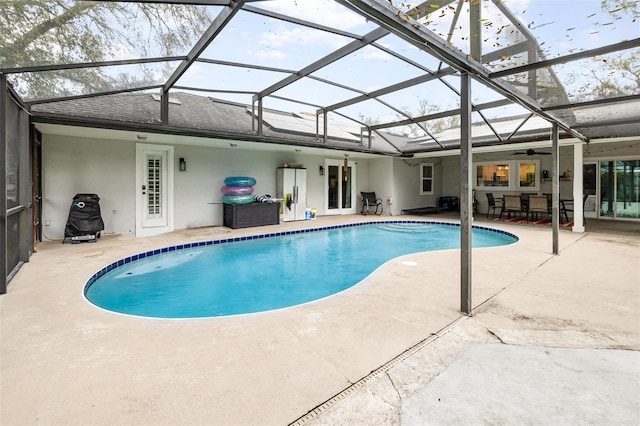 outdoor pool with a ceiling fan, a lanai, and a patio