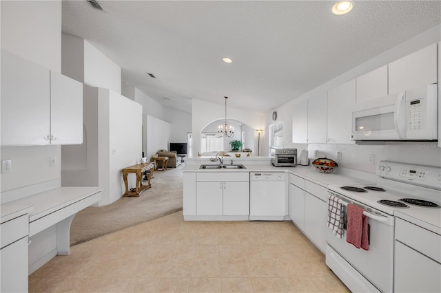 kitchen featuring a notable chandelier, light countertops, light colored carpet, open floor plan, and white appliances