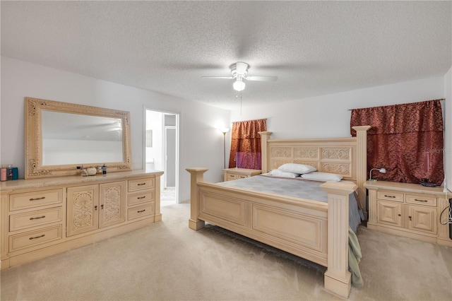 bedroom with light carpet, ceiling fan, and a textured ceiling