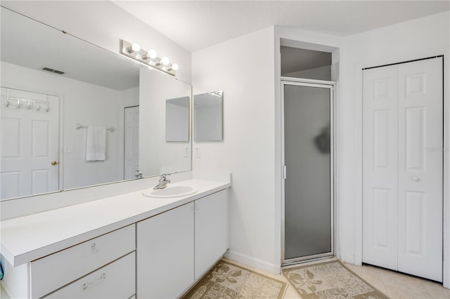 bathroom with tile patterned flooring, a closet, visible vents, and vanity