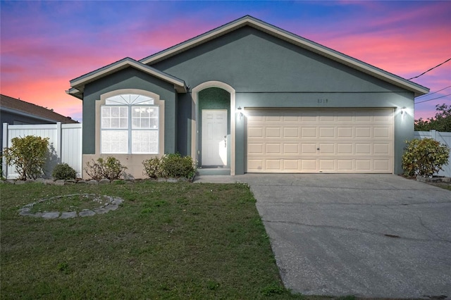 ranch-style house with a garage, concrete driveway, fence, and stucco siding