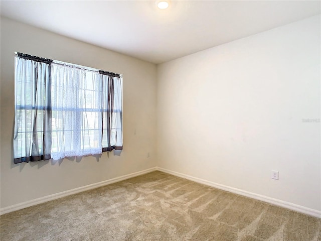 carpeted spare room with baseboards