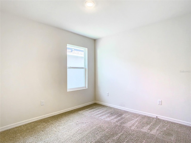 carpeted spare room with baseboards