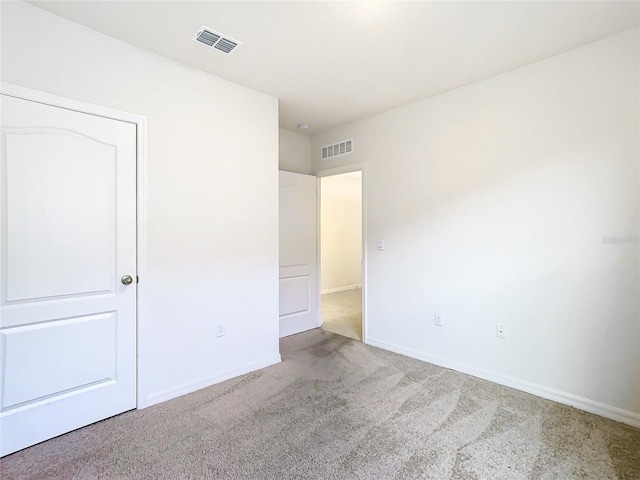 unfurnished bedroom with visible vents, light carpet, and baseboards