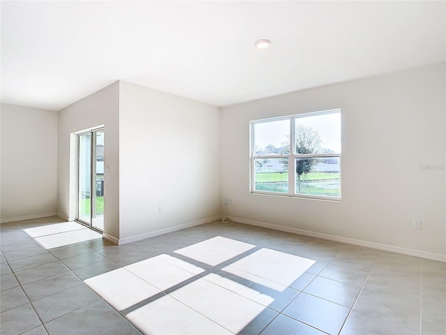 empty room featuring light tile patterned flooring and baseboards