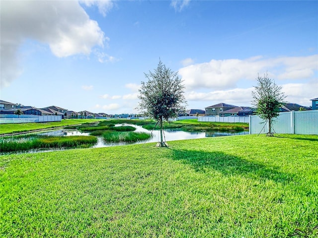 view of yard featuring a water view and fence