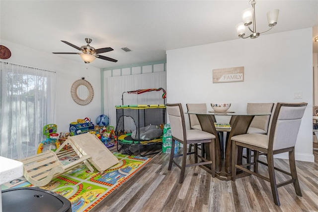 recreation room featuring hardwood / wood-style floors and ceiling fan with notable chandelier