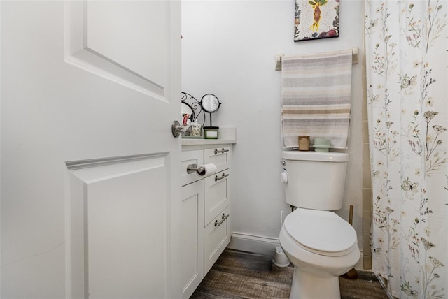 bathroom with toilet, a shower with shower curtain, and wood-type flooring