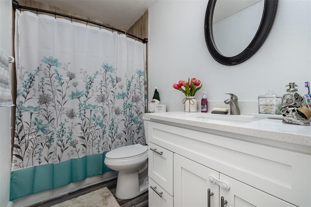 bathroom featuring curtained shower, wood-type flooring, vanity, and toilet