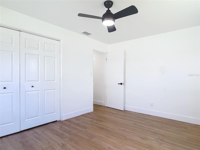 unfurnished bedroom with light wood-type flooring, a closet, and ceiling fan