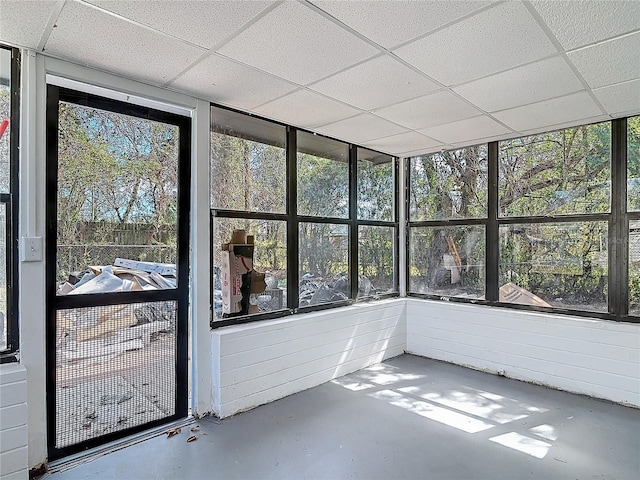 unfurnished sunroom featuring a drop ceiling