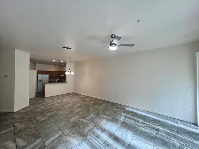 unfurnished living room with baseboards, visible vents, and a ceiling fan