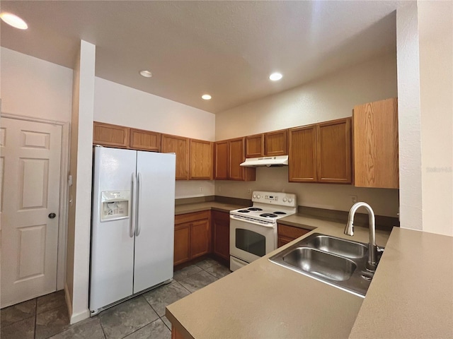 kitchen with under cabinet range hood, white appliances, a sink, light countertops, and brown cabinetry