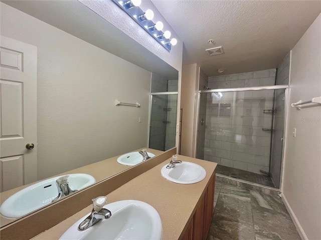 full bathroom with a sink, a textured ceiling, and double vanity