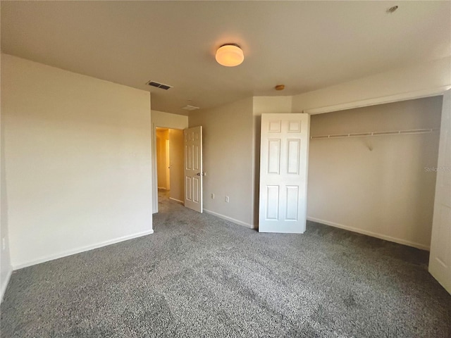 unfurnished bedroom featuring dark colored carpet, a closet, visible vents, and baseboards