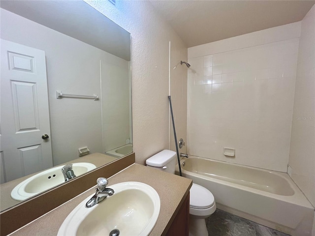 full bathroom featuring tub / shower combination, a textured wall, vanity, and toilet