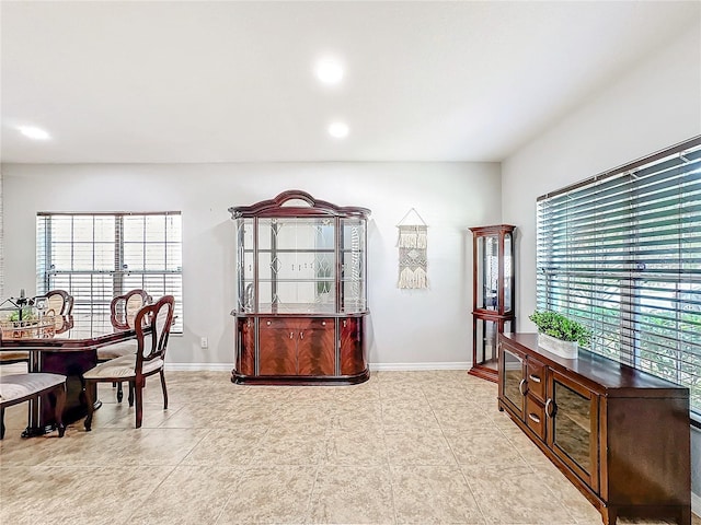 home office with recessed lighting, light tile patterned flooring, plenty of natural light, and baseboards