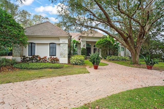 view of front facade featuring a tile roof and stucco siding