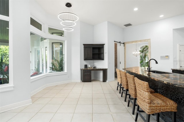 5138 Fairway Oaks Dr, Windermere, FL 34786 - kitchen featuring a barn door, visible vents, dark stone counters, and a sink