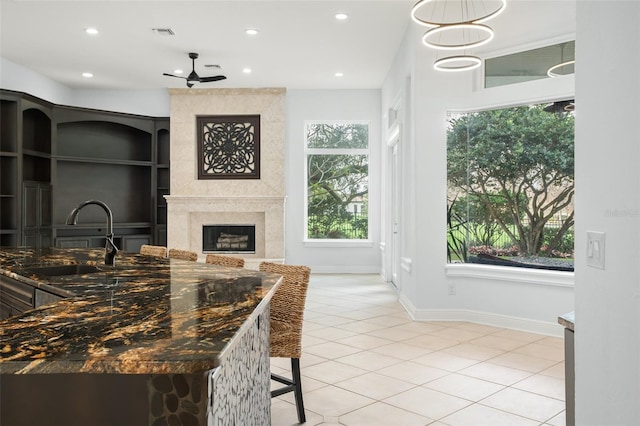 5138 Fairway Oaks Dr, Windermere, FL 34786 - kitchen featuring light tile patterned floors, recessed lighting, visible vents, a large fireplace, and a sink