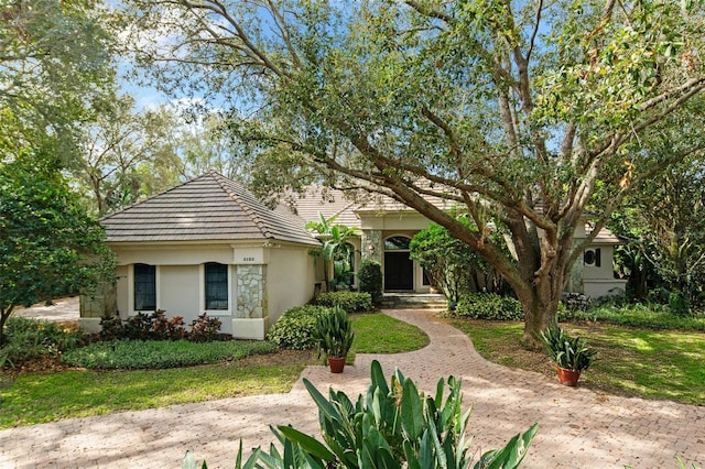 5138 Fairway Oaks Dr, Windermere, FL 34786 - view of front facade featuring stone siding, a tiled roof, and stucco siding