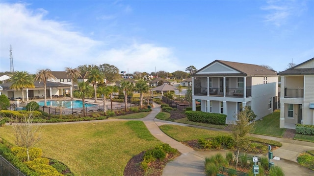 view of home's community featuring a pool and a yard