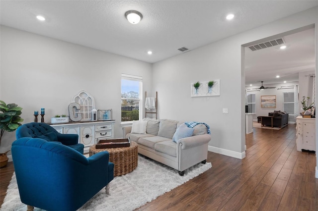 living room with dark wood-type flooring and a textured ceiling