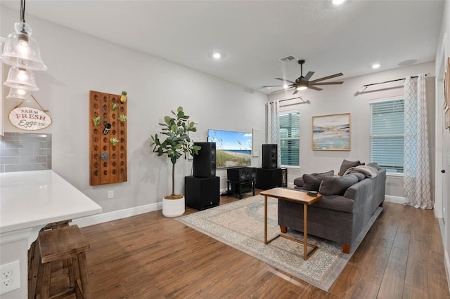 living room featuring ceiling fan and dark wood-type flooring