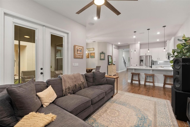 living room with light wood-type flooring, french doors, sink, and ceiling fan