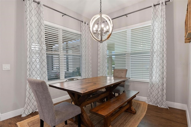 dining space with dark wood-type flooring and a notable chandelier