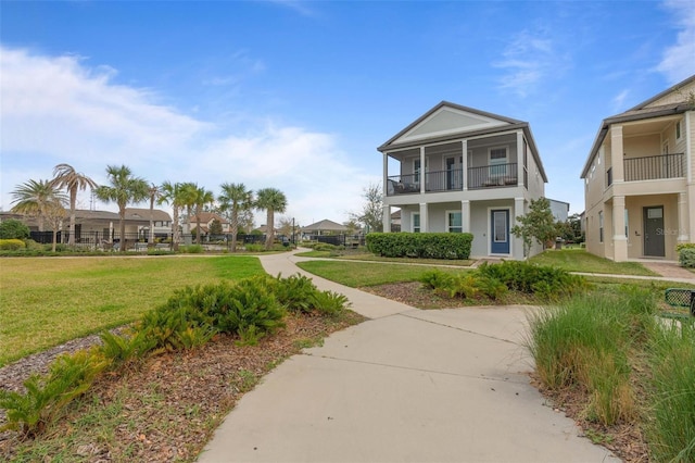 view of front of home featuring a front lawn and a balcony