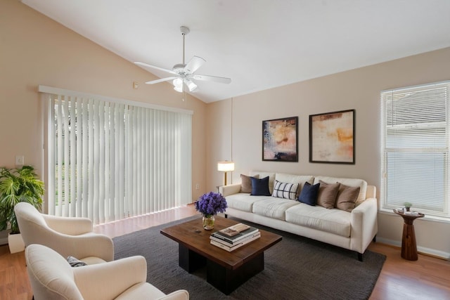 living area with lofted ceiling, ceiling fan, baseboards, and wood finished floors