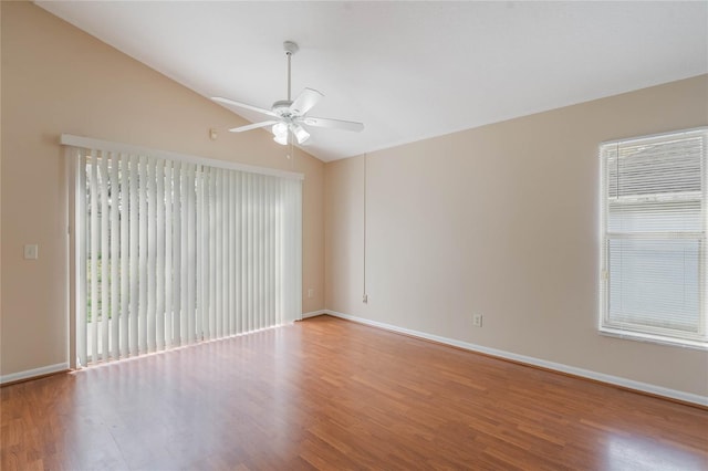 spare room featuring vaulted ceiling, baseboards, and wood finished floors