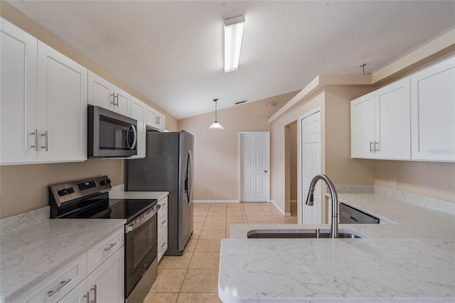 kitchen with pendant lighting, stainless steel appliances, a sink, and white cabinets