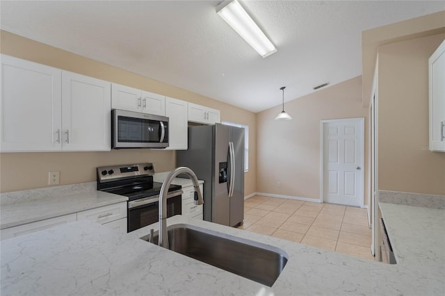 kitchen with hanging light fixtures, appliances with stainless steel finishes, vaulted ceiling, a sink, and light stone countertops