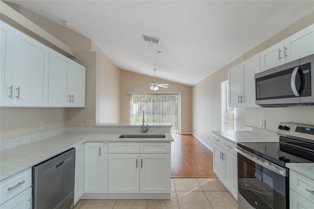 kitchen featuring light tile patterned floors, stainless steel appliances, visible vents, white cabinetry, and a sink