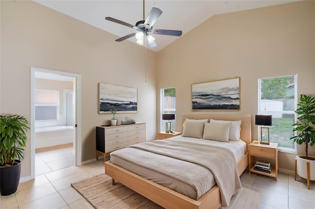 bedroom featuring light tile patterned floors, high vaulted ceiling, connected bathroom, and baseboards