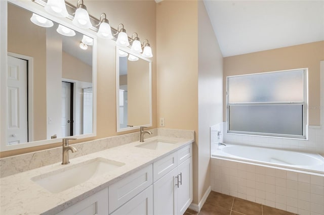 full bathroom with vaulted ceiling, a sink, a bath, and tile patterned floors