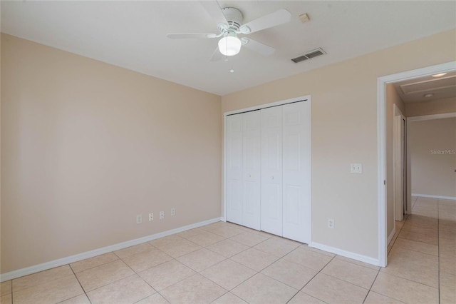 unfurnished bedroom featuring light tile patterned floors, a closet, visible vents, a ceiling fan, and baseboards