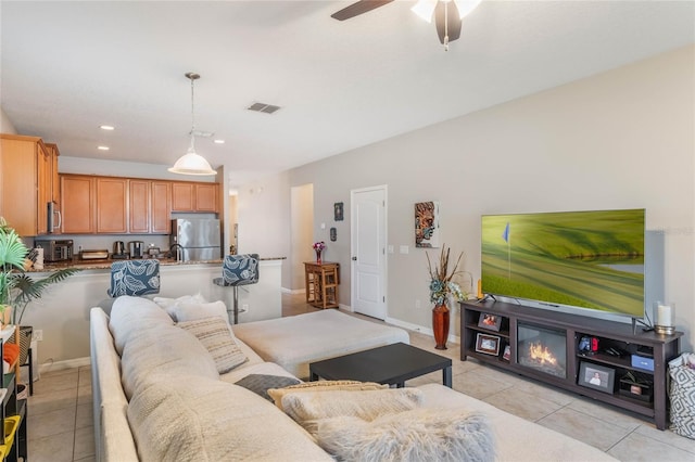 living area featuring light tile patterned floors, ceiling fan, recessed lighting, visible vents, and baseboards