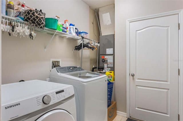 washroom featuring laundry area, washing machine and dryer, and light tile patterned flooring