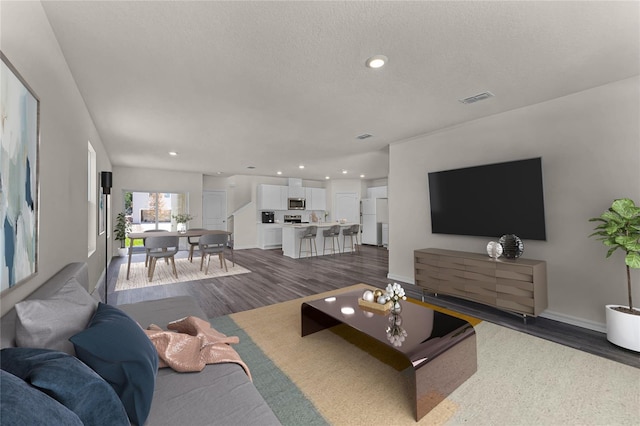 5614 Paddock Fence Ln, Apopka, FL 32712 - living room featuring a textured ceiling and dark hardwood / wood-style floors