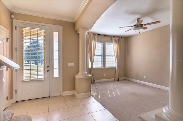 foyer entrance featuring ornate columns, crown molding, light tile patterned flooring, and ceiling fan